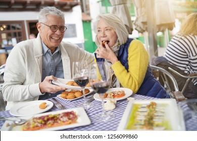 Attractive Senior Couple Eating Tapas Outdoors