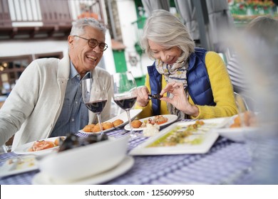 Attractive Senior Couple Eating Tapas Outdoors