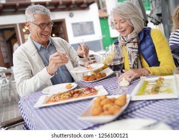 Attractive Senior Couple Eating Tapas Outdoors