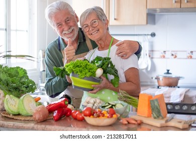 Attractive senior couple preparing vegetables together in the home kitchen. Caucasian elderly people enjoying healthy eating - Powered by Shutterstock