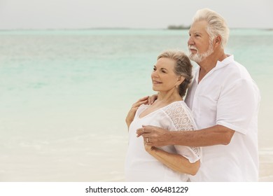 Attractive senior male and female Caucasian couple in white casual clothes on a tropical vacation beach - Shutterstock ID 606481229