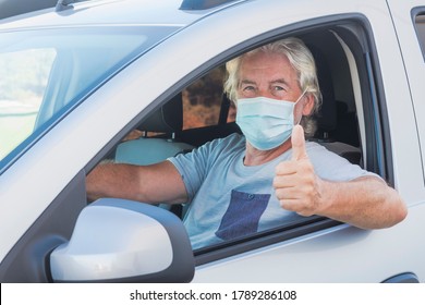 Attractive Senior Man Driving His Silver Car Wearing Medical Mask Due To Coronavirus Happy For End Lockdown At Home