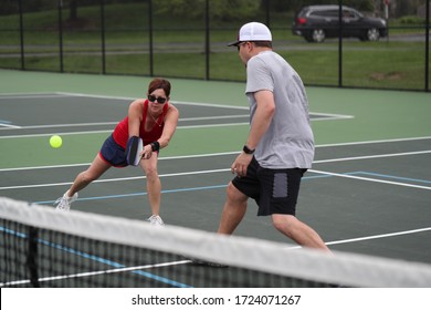 An Attractive Senior, Playing Pickleball, Hits A Two-handed Backhand.