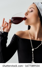 Attractive Sensual Nun Drinking Red Wine From Glass Isolated On Grey