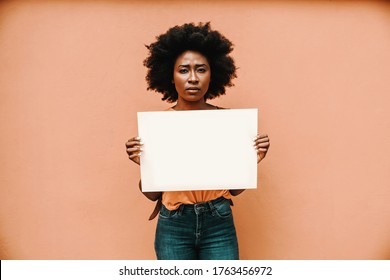 Attractive Serious African Woman Standing And Holding Blank Paper.