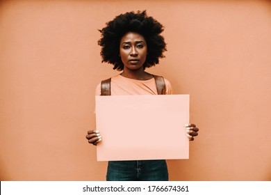 Attractive Serious African Woman Standing And Holding Blank Paper.