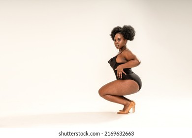 Attractive Sexy Woman In Black Fashionable One Piece Swimsuit, Looking At The Camera. Full Photo Of Superb Plus Size Girl Posing In Studio On The Gray Background. Copy Space. 