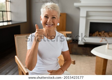 Attractive smiling senior lady shoring thumbs up, happy with life, good mood. Mature woman express love for life, value every moment. Appreciation, emotion, lust for life concept. Copy space