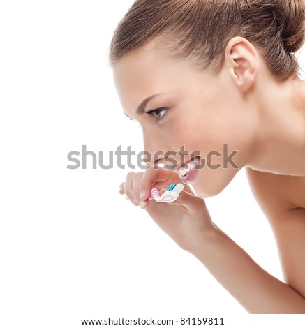 attractive smiling woman brushing her teeth on white background