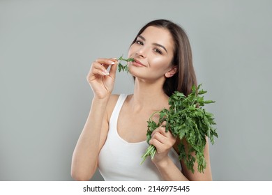 Attractive Smiling Woman Eating Salat Parsley On White Studio Background