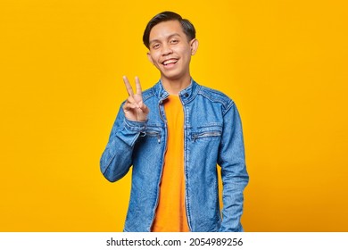 Attractive Smiling Young Asian Man Doing Peace Sign With Hand