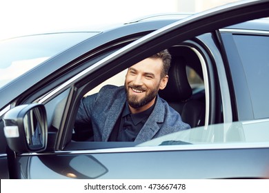 Attractive smiling young man in a car