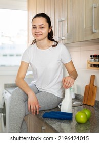 Attractive Smiling Young Woman Cleaning Kitchen Counter With Spray Bottle And Rag