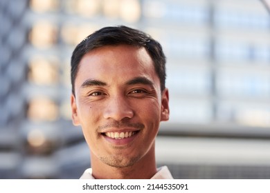 An Attractive South East Asian Man Smiles For A Portrait Outside City Building