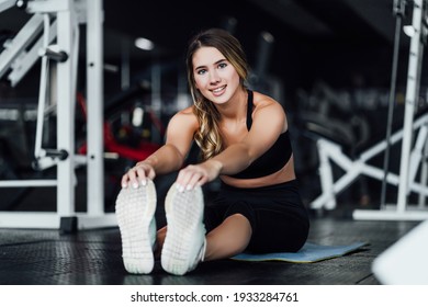 Attractive Sports Girl Smiles And Looks At The Camera While Stretching Her Body In The Gym, Lifestyle, Healthy Lifestyle.
