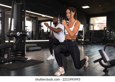 Attractive sports people are working out with dumbbells at gym - Powered by Shutterstock