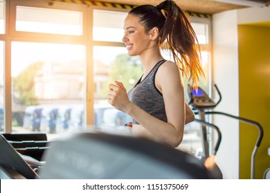 Attractive Sportswoman On Running Track Machine In Gym.