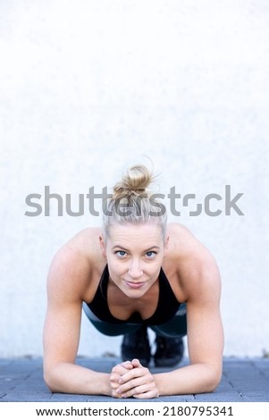 Similar – Young woman stretching arms before training outdoors