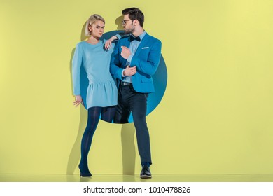 Attractive Stylish Couple Stepping Through Aperture On Yellow