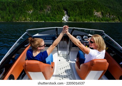 Attractive Successful Young European Females On Travel Tourism Vacation Enjoying Their Boat Trip In Summer  On Remote Canadian Lake British Columbia