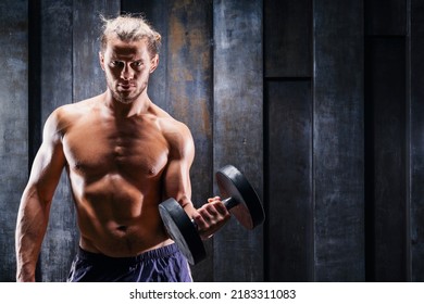 Attractive Tall Muscular Bodybuilder With Naked Torso Doing Exercises. Lifting Dumbbells For Bigger Biceps. Close Up Handsome Man With Big Biceps Lifting Weights. Fitness Center, Healthy Life Concept.