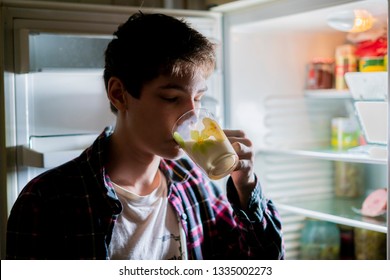 Attractive Teen Drinking Cool Milk From The Fridge At Night