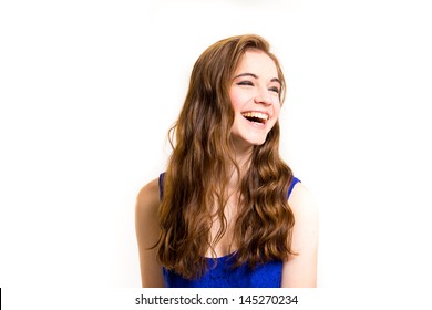 An attractive teen poses for a photo indoors in a lighting studio against a white background with a fashion style feel to the image. - Shutterstock ID 145270234