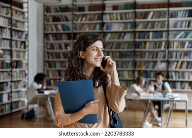 Attractive Teenage Student Girl Talks On Smartphone Standing In Public Or University Library, Speaks To Mate Discuss Class Timetable. Generation Z, Modern Wireless Tech Usage, Communication Concept