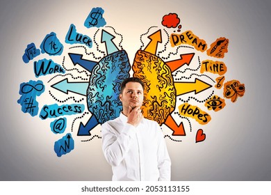 Attractive thoughtful young european businessman with creative drawing of different brain hemispheres on concrete wall background. Brainstorming, solution and emotion concept