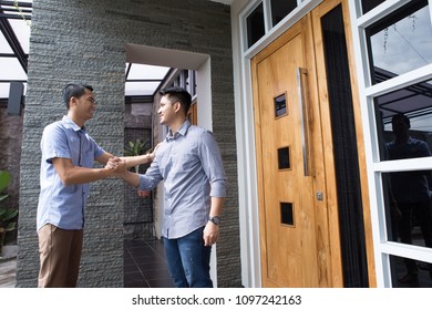 Attractive two men are greeting and shaking each other