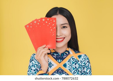 Attractive Vietnamese woman wearing traditional costume, isolated on yellow background
