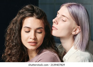 Attractive Wavy-haired Woman Feeling Breath Of Her Girlfriend With Light Purple Hair