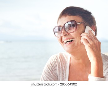 attractive woman of 50 years with a mobile phone - Powered by Shutterstock