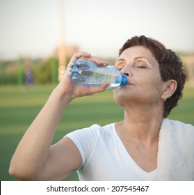 Attractive Woman 50 Years Old, Drinking Water After Fitness, Outdoors