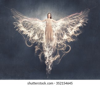 Attractive woman with angel wings on sky background