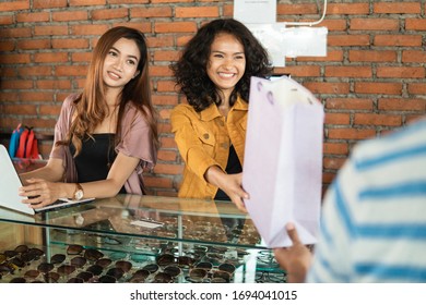 Attractive Woman Asian Shop Keeper Giving Shopping Bag To Customer