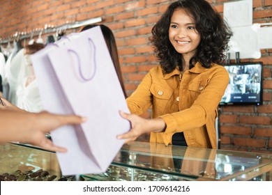 Attractive Woman Asian Shop Keeper Giving Shopping Bag To Customer