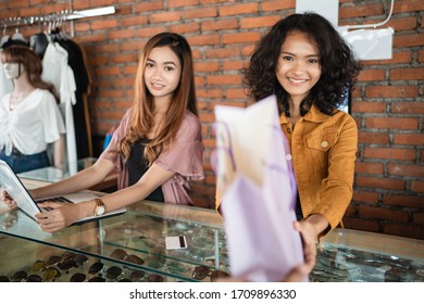 Attractive Woman Asian Shop Keeper Giving Shopping Bag To Customer