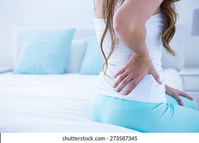 Attractive Woman With Back Pain At Home In The Bedroom