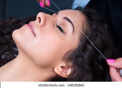Attractive Woman In Beauty Salon On Facial Hair Removal Threading Procedure