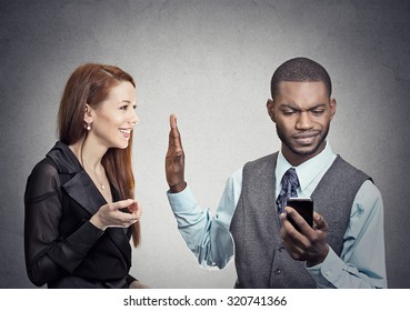Attractive woman being ignored stopped by young handsome man looking at smartphone reading browsing internet isolated on gray wall background. Phone addiction concept. Human face expression emotions 