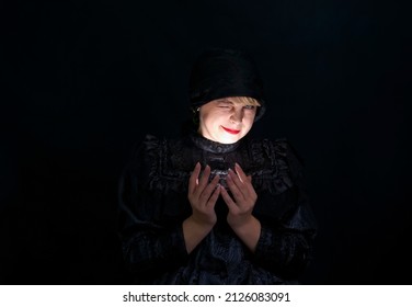 Attractive Woman In Black Clothes Holding A Light Source In Her Hands