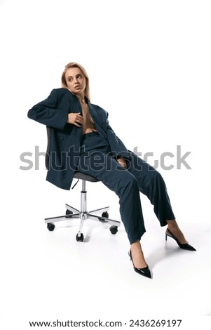 attractive woman with blonde hair in fashionable unbuttoned blazer sitting on chair and looking away Foto d'archivio © 