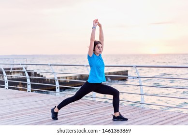 Attractive Woman In Blue Shirt Doing Deep Lung With Hans Up Seashore At Sunrise