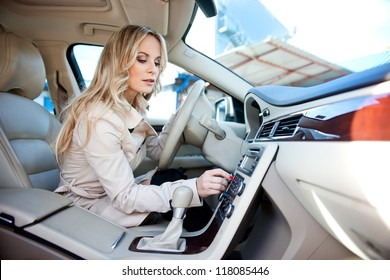 Attractive Woman In Car Driver Seat Adjusting Radio