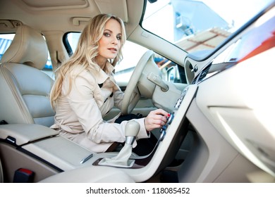 Attractive Woman In Car Driver Seat Adjusting Radio