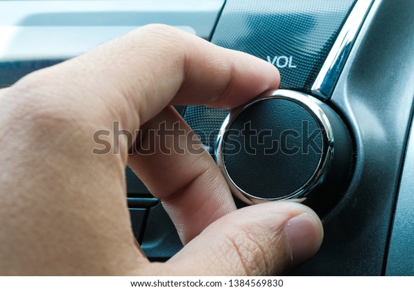 attractive woman in\
car driver seat adjusting radio, hand pressing phone button on\
steering wheel in the car.\
