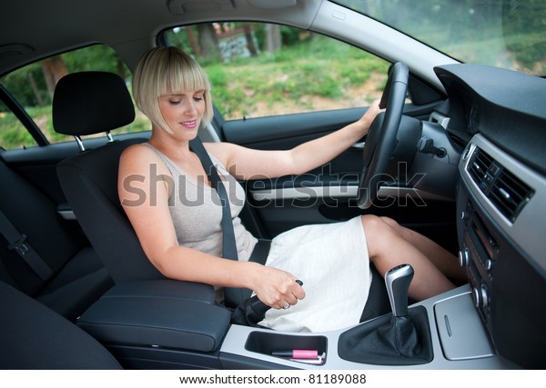 attractive woman in the\
car using hand brake