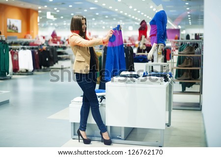 Attractive woman choosing cloths in shop