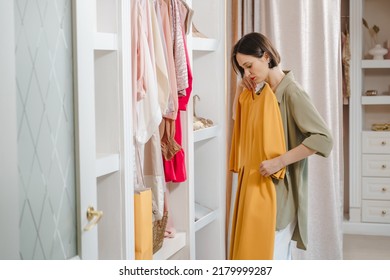 Attractive woman choosing a dress in a dressing room or store. Fashion, style and space organization concept. - Shutterstock ID 2179999287